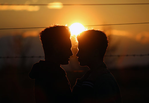 Junges schwules Liebespaar bei Sonnenuntergang