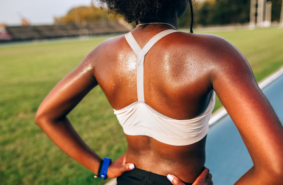 Black athlete woman on her back in an athletics stadium