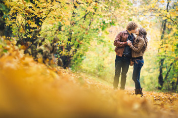Fototapeta premium Loving couple kissing among beautiful autumn maples.