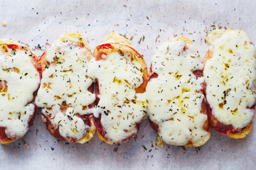 Hot homemade grilled toasts with cheese and meat on white paper top view