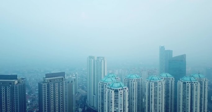 JAKARTA, Indonesia - July 17, 2018: Beautiful aerial scenery of apartment buildings on misty morning in Jakarta downtown. Shot in 4k resolution