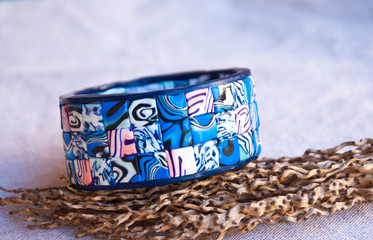Handmade jewelry from polymer clay. Blue mosaic bracelet. Marine bangle. Jewelry background.