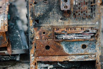 Rear side of a burned desktop computer. USB and other ports scorched and covered with rust. Completely destroyed machine, rendered useless.