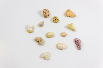 Fototapeta na wymiar Top shot of several random positioned colorful stones that collected from beach on white background