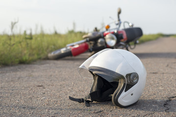Photo of helmet and motorcycle on the road, the concept of road accidents