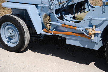 Jipe de todo o terreno antigo e restaurado de cor azul c&eacute;u - 4x4 willys jeep, com ferramentas fixadas na lateral do carro