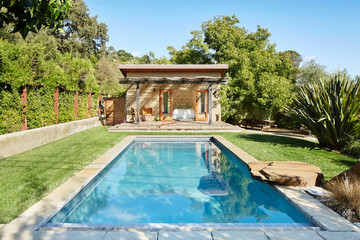 Pool and pool house in backyard of home in California