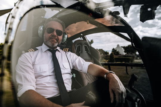 Pilot sitting in the cockpit of a private helicopter