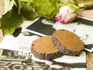 Homemade chocolate cookies with a poppy edge on a background of old photos and withered roses. Food baking. Copy space