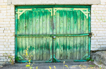 old green wooden garage doors with a lock