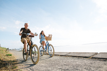 Healthy, active couple enjoying life riding cruiser bikes near o