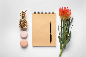 Creative flat lay composition with tropical flower, notebook and macaroons on white background