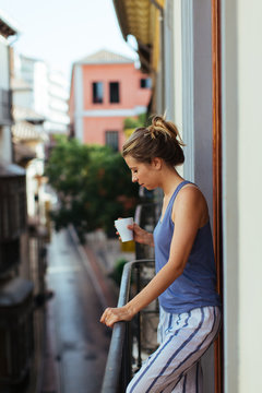 Woman having breakfast on the balcony, Granada, Spain.