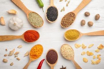 Fotobehang Flat lay composition with different aromatic spices in spoons on wooden background © New Africa