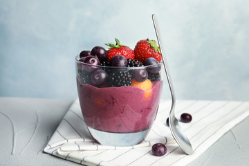 Glass with tasty acai smoothie on gray table