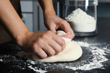 Woman kneading dough for pastry on table