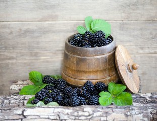 Ripe blackberry in a wooden plate