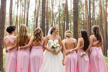 Bride and bridesmaids in pink dresses having fun at wedding day. Happy marriage and wedding party...