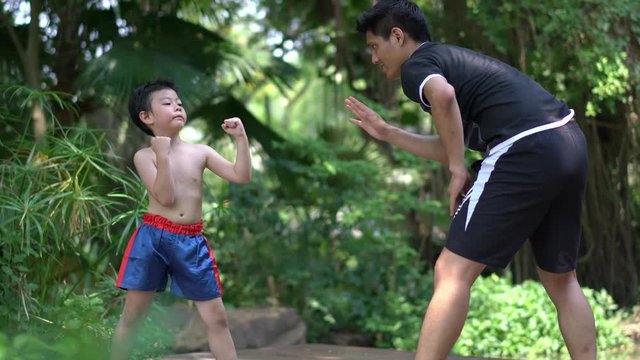 Asian little chinese boy study thai boxing with coacher. concept of sport exercise.