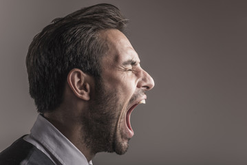 Furious angry young business man shouting and yelling, side view and closeup - 215897116