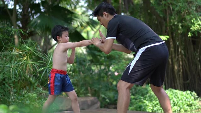 Asian little chinese boy study thai boxing with coacher. concept of sport exercise.