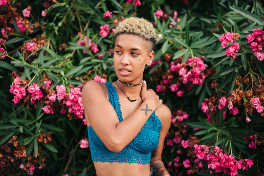 Multiracial young woman with tattoos and dyed afro hair