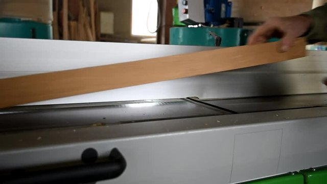 Processing wood with electrical plane in workshop