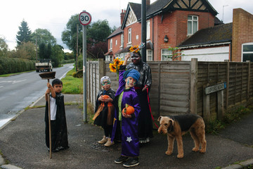 Four children and a dog go trick or treating.