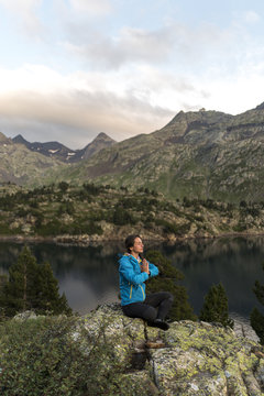 Female hiker meditating in an alpine scenery