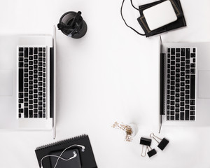 Flat lay of two laptops on a white table.