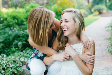 Two young girls laughing and hugging