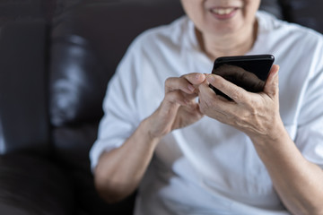 Elderly woman using her phone in home