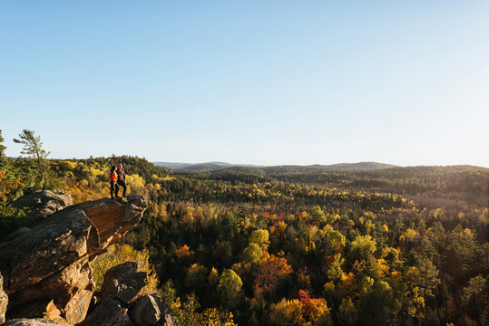 Couple standing on edge of cliff looking at beautiful view
