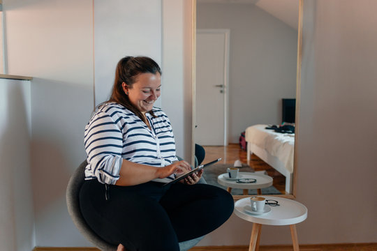 Woman at her Home Looking at Computer Tablet
