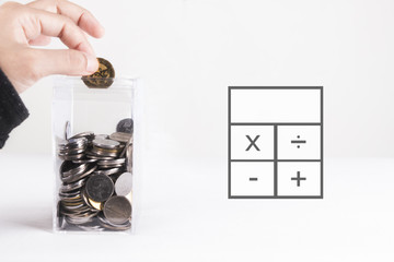 Saving concept. Hand inserting coin into square transparent box. 