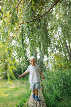 Little boy walking along log outside