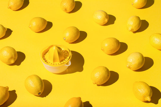 Lemons and juicer on yellow background