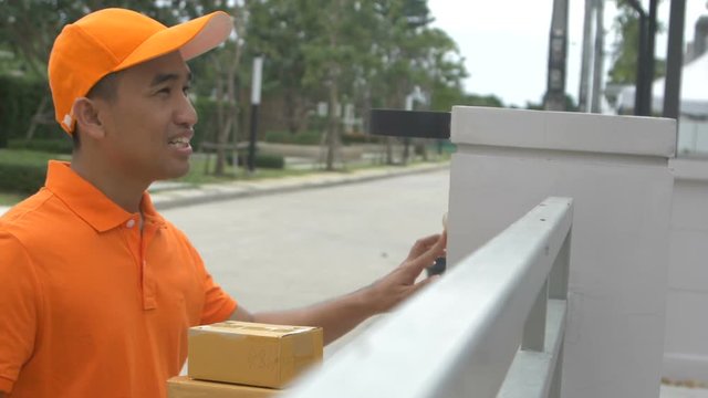 Delivery man ring a bell to call customers for receive a parcel at front home