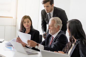 Marketing team consulting sales plan with supervisor senior manager in conference room before presenting to client.