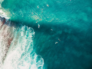 Aerial view with surfers and barrel wave in tropical blue ocean. Top view