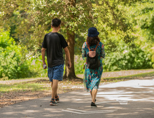 unknown couple take a walk in the park after a long work day