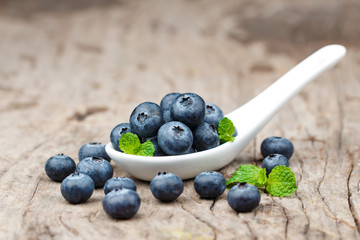 Blueberries in white spoon on wooden table, Healthy eating and nutrition concept