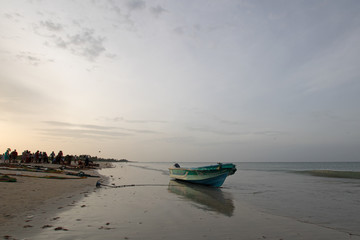 Obraz premium Beached and anchored small fishing boat at sunset on Nilaveli beach in Trincomalee Sri Lanka Asia