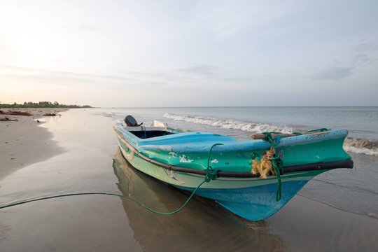 Small fishing boat at sunset on Nilaveli beach in Trincomalee Sri Lanka