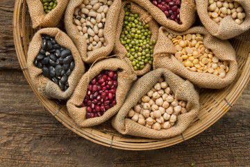 Legumes seed bean in sack bag on wooden background, top view. Dried food, Protein from plant,...