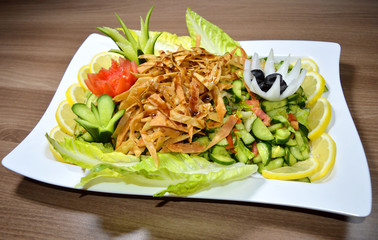 Salad with cheese and fresh vegetables isolated on wooden background. 
