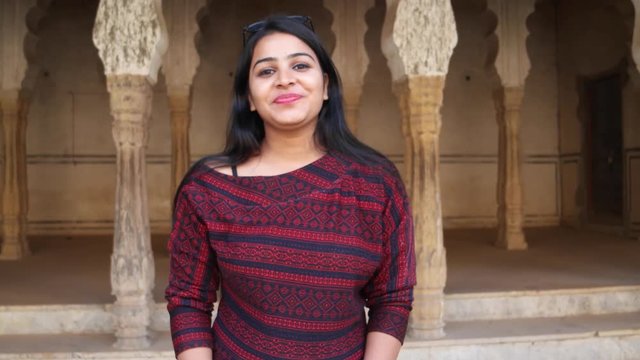 Cute young lady angry looks around smiles happy livid points finger straight at camera warns giving instructions order firing pissed lover POV handheld mid shot date late consequences at a temple