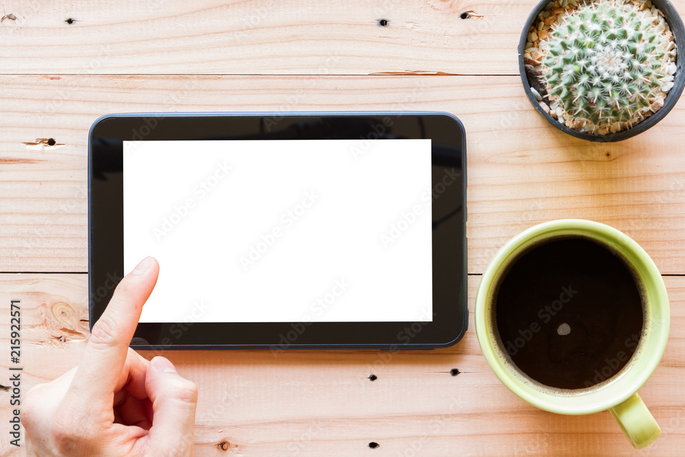 Wall mural hand using tablet computer with blank white screen on wooden background