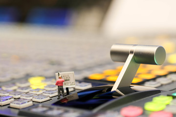 Miniature people : worker on Switcher buttons in studio TV station, Audio and Video Production Switcher of Television Broadcast.