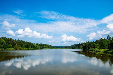 Fototapeta premium landscape view of lake in sunny summer day. sky reflection in water